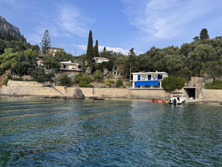 Paleokastritsa bay with clear water below olive-covered hills, Corfu