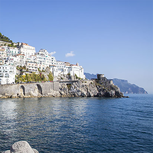 Stunning view of the Amalfi Coast, with houses perched on cliffs overlooking the Mediterranean Sea. Click to explore our comprehensive guide to Italy's diverse destinations.